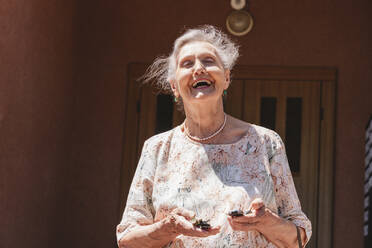 Ältere Frau mit Autoschlüssel lachend an einem sonnigen Tag - OSF00991