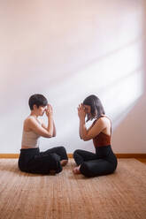 Friends practicing yoga together in front of each other - MMPF00292