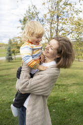 Glückliche Mutter mit ihrem Sohn im Park stehend - LESF00289