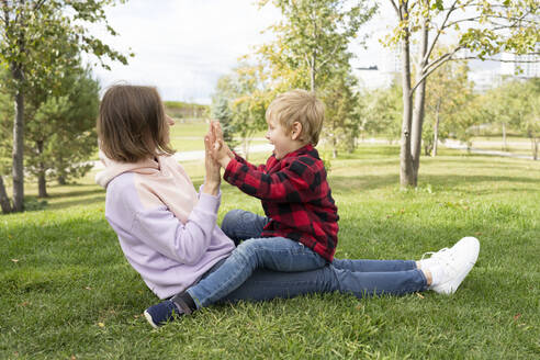 Mutter mit Sohn beim Klatschspiel im Park - LESF00293