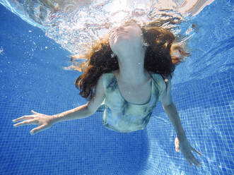 Mädchen schwimmt unter Wasser im Pool - MEGF00126