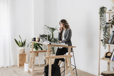 Junge Ingenieurin bei der Arbeit in einem modernen, nachhaltigen Büro - EBBF06506