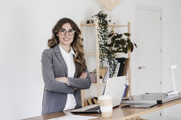 Confident female engineer standing in her modern office with arms crossed - EBBF06547