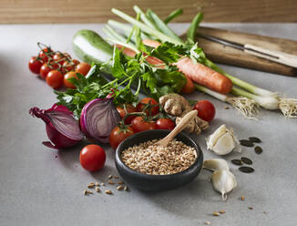 Bowl of grains, garlic, ginger, pumpkin seeds, parsley and various raw vegetables - KSWF02248