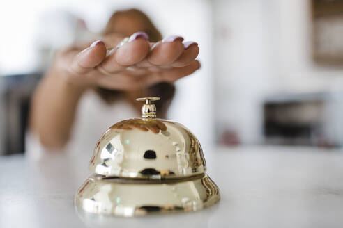 Hand of businesswoman ringing service bell at restaurant - DCRF01521