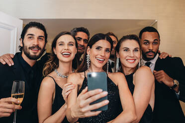 Frau mit Freunden, die ein Selfie auf einer Gala-Veranstaltung machen. Multi-ethnische Gruppe von Menschen, die ein Selfie auf einer Party machen. - JLPPF00072