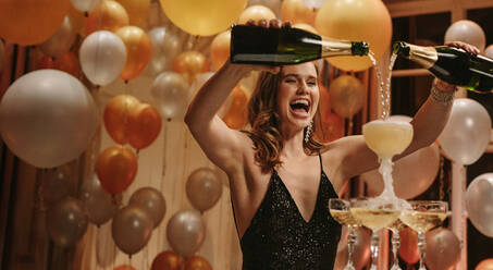 Aufgeregte junge Frau füllt Champagner in einen Turm Gläser bei Gala-Nacht-Party. Schöne weibliche socialite genießen bei neuen Jahren Partei. - JLPPF00080