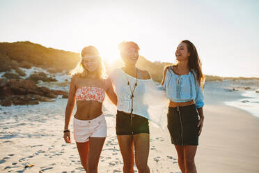 Aufnahme von stilvollen jungen Frauen, die sich am Meer amüsieren. Freundinnen, die an einem Sommertag am Strand spazieren gehen und Spaß haben. - JLPPF00227