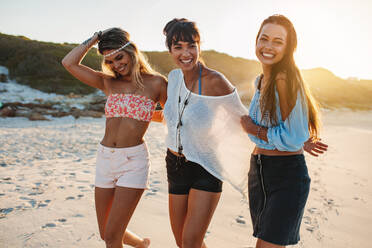 Portrait of young people walking along the beach on a summer day. Group of female friends on the beach together. - JLPPF00228