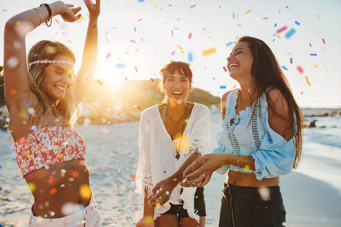 Aufnahme von glücklichen jungen Freundinnen, die am Strand feiern. Drei junge Frauen haben Spaß auf einer Strandparty. - JLPPF00241