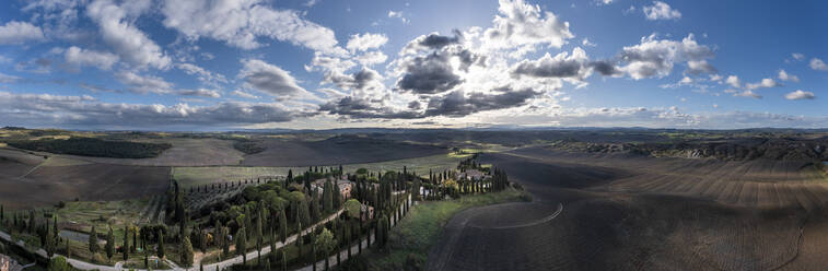 Italien, Toskana, Leonina, Luftbildpanorama von Feldern und baumbestandener Landstraße bei Sonnenuntergang - AMF09591