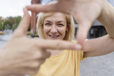 Glückliche reife Frau macht Fingerrahmen - TOF00125