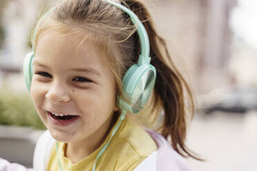 Glückliches Mädchen, das über Kopfhörer Musik hört - TOF00134