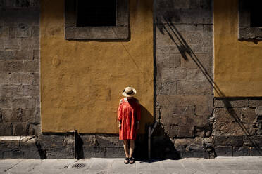 Woman wearing sun hat in front of brown wall - FLLF00730