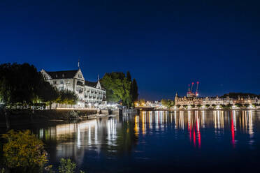 Deutschland, Baden-Württemberg, Konstanz, Bodenseeufer bei Nacht mit Stadtbeleuchtung im Hintergrund - DIGF18843