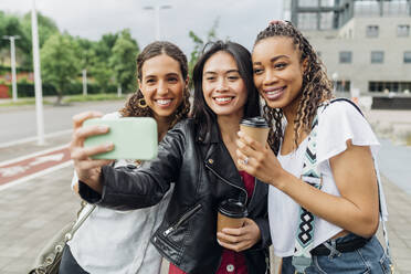 Lächelnde Frau nimmt Selfie mit Freunden auf Smartphone - MEUF08113