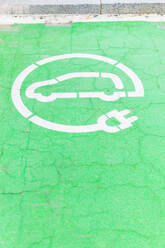 From above of green painted road with electric car charging station sign on city street - ADSF38696