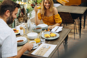 Couple enjoying a tasty breakfast at a hotel. Happy married couple smiling cheerfully while having a meal together at a dining table. Middle aged couple enjoying a romantic vacation at a holiday resort. - JLPPF00352