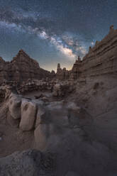 Unusual rock formations located against magnificent starry sky at night in dry desert - ADSF38786