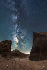 Unusual rock formations located against magnificent starry sky at night in dry desert - ADSF38788