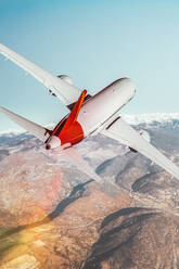 Blick von hinten auf ein Verkehrsflugzeug, das über die Berge fliegt. Mischung aus 3D- und Rasterbildern - ADSF38812