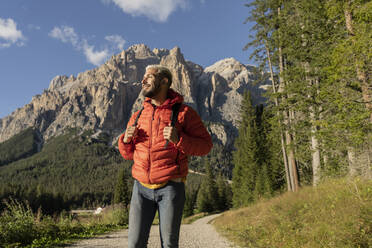 Lächelnder Wanderer mit Rucksack vor den Dolomiten, Italien - JCCMF07337