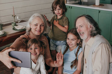 Großmutter mit Enkelkindern, die ein Selfie über einen Tablet-PC zu Hause machen - YTF00121