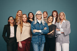 Portrait of a happy group of women standing together in a studio. Women of different ages smiling at the camera cheerfully. Diverse group of strong independent women feeling empowered. - JLPPF00611