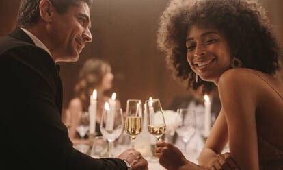 Schönes Paar auf einer Silvesterparty. Liebender Mann und Frau auf einer Gala-Dinnerparty mit Getränken. - JLPPF00680