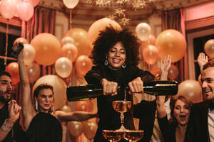 Afrikanische junge Frau füllt Champagner-Pyramide mit Freunden tanzen auf Gala-Nacht-Party. Multi-ethnischen Gruppe von geselligen Menschen, die eine tolle Zeit auf Neujahrs-Party. - JLPPF00710