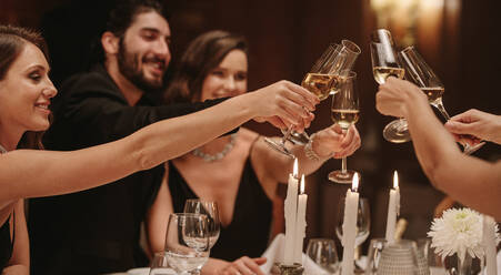 Eine Gruppe von Freunden trinkt bei einem Gala-Dinner. Eine Gruppe von Männern und Frauen genießt eine Dinnerparty. - JLPPF00718