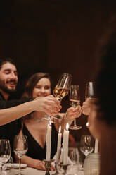 Eine Gruppe von Männern und Frauen feiert eine Party mit Champagner. Menschen der High Society stoßen bei einer Dinnerparty mit Getränken an. - JLPPF00720