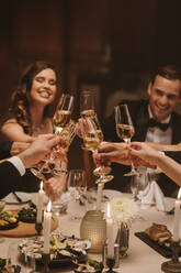 Freunde stoßen auf einer Dinnerparty mit Getränken an und feiern das neue Jahr mit Drinks. - JLPPF00735