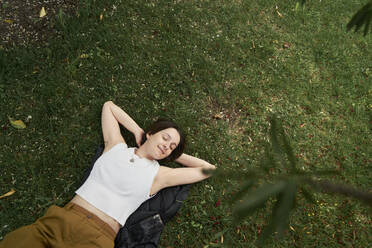 Frau mit geschlossenen Augen entspannt im Garten - ANNF00021