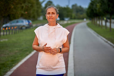 Selbstbewusste Frau auf der Sportbahn stehend - ZEDF04772