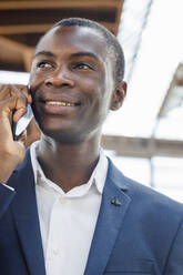 Happy young businessman talking on mobile phone - IFRF01726