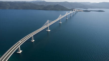 Luftaufnahme der Peljeski-Brücke, einer Hängebahn und Schnellstraße über die Bucht von Mali Ston in Kroatien. - AAEF15821
