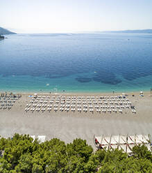 Luftaufnahme von aufgereihten Sonnenliegen am Strand von Zlatni Rat in Bol auf der Insel Brac, Kroatien. - AAEF15839