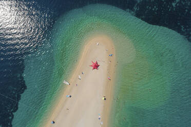 Luftaufnahme eines sternförmigen Sonnenschirms am Strand von Zlatni Rat in Bol auf der Insel Brac, Kroatien. - AAEF15843
