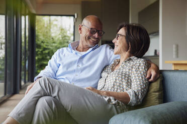 Verliebtes älteres Paar sitzt zu Hause auf dem Sofa - RBF08950