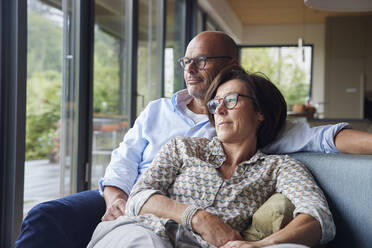 Liebevolles älteres Paar verbringt Zeit miteinander auf dem Sofa zu Hause - RBF08957