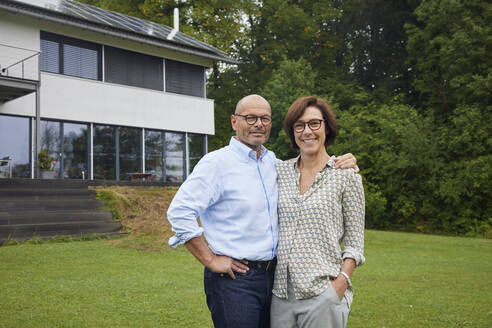 Glücklicher älterer Mann und Frau stehen zusammen im Vorgarten - RBF09028