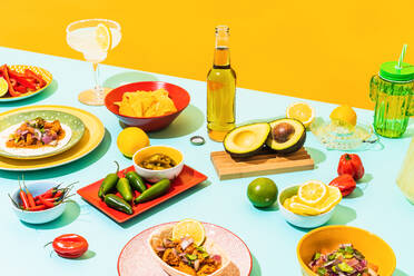 Von oben: verschiedene traditionelle mexikanische Gerichte und Getränke auf dem blauen Tisch an der gelben Wand - ADSF38853