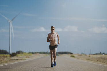 Hemdloser junger Sportler läuft auf der Straße - MTBF01255