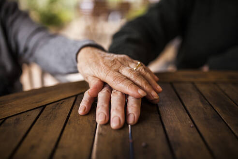 Älteres Paar legt Hand auf Hand als Zeichen der Liebe - ADSF38914