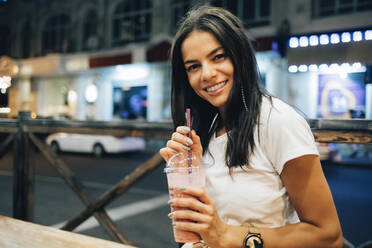 Happy beautiful woman with smoothie at sidewalk cafe - OYF00801