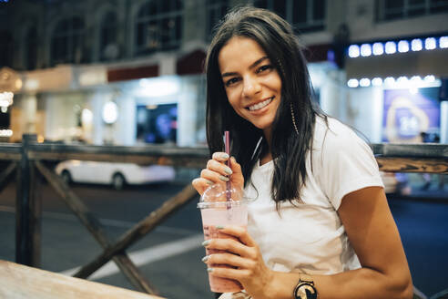 Glückliche schöne Frau mit Smoothie in einem Straßencafé - OYF00801