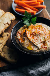 Leckerer Hummus mit Paprika, Olivenöl und etwas Brot zum Dippen - ADSF38948