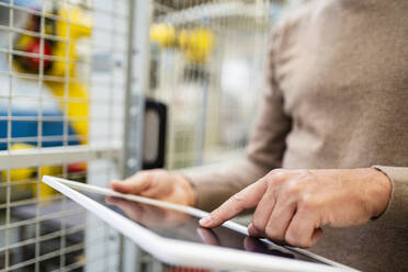 Hand of engineer using tablet PC at factory - DIGF18864