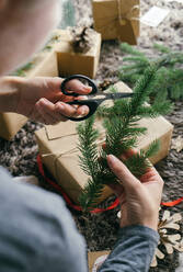 Frau bereitet Ornamente zum Einpacken eines Weihnachtsgeschenks vor - ADSF39010